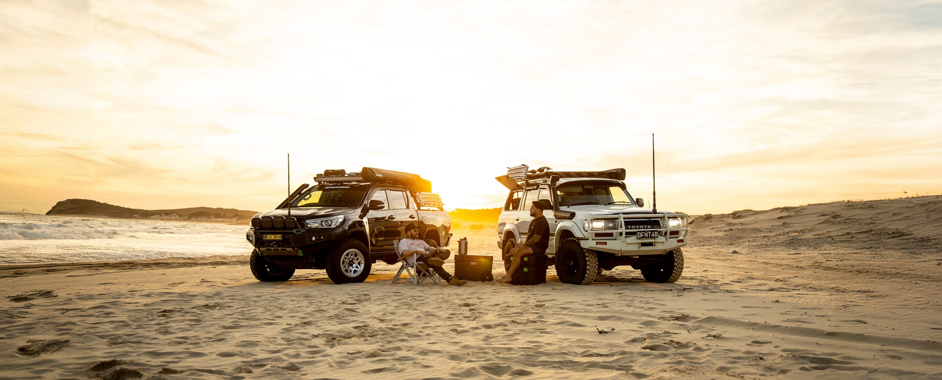 Co-founders talking about Dexon’s story by the beach, next to their modified 4x4 fitted with Dexon lights.