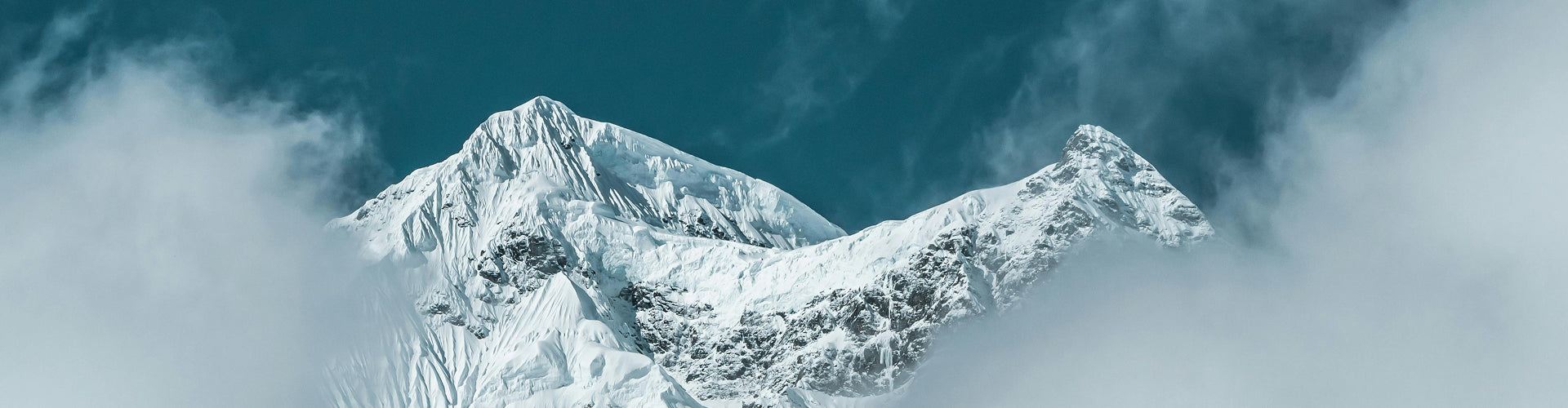 Snowy mountain peak with clouds in the background